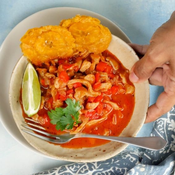 Traditional Dominican lambi conch stew with fried tostones