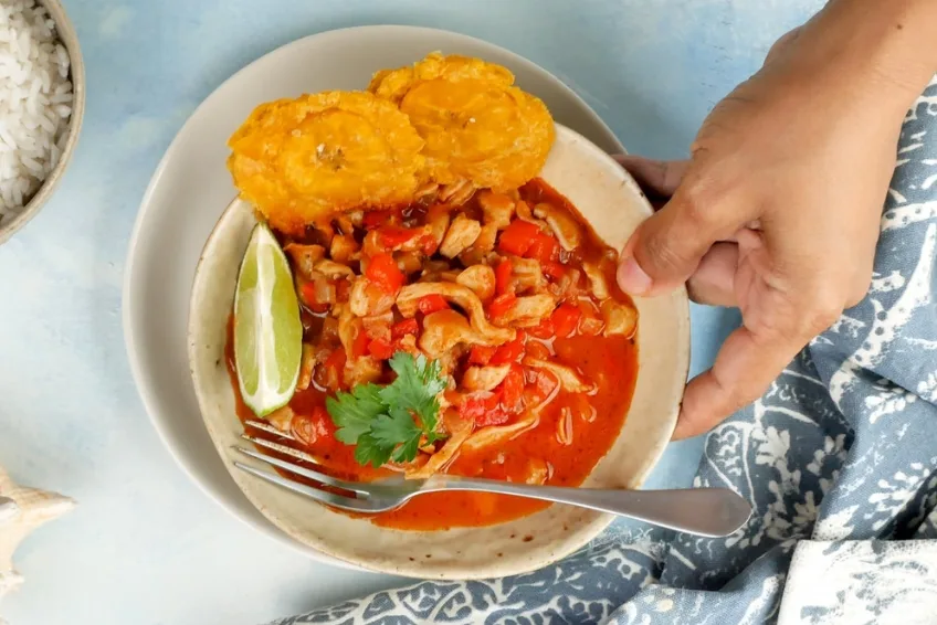 Traditional Dominican lambi conch stew with fried tostones