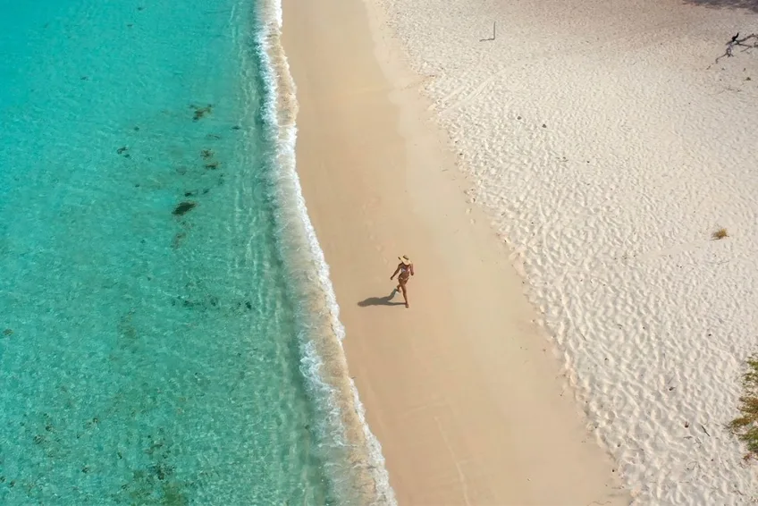 Solo traveler strolling pristine Bahia de las Aguilas beach