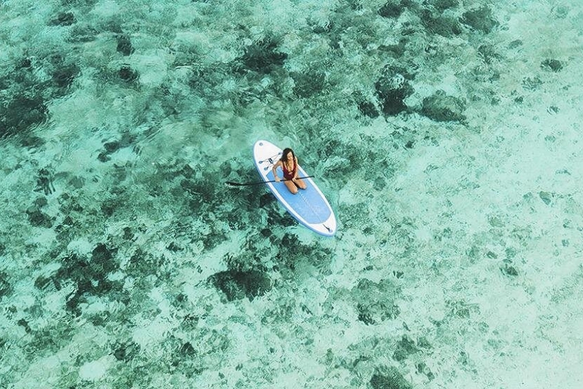 Paddleboarder over clear turquoise waters at Port Cabo Rojo, Dominican Republic